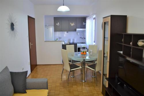 a dining room and kitchen with a table and chairs at Apartment Doriana in Srima