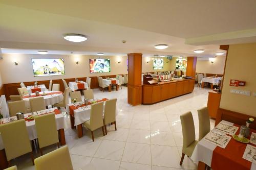 Hotel Barbakán في بيتْش: غرفة طعام مع طاولات وكراسي في مطعم