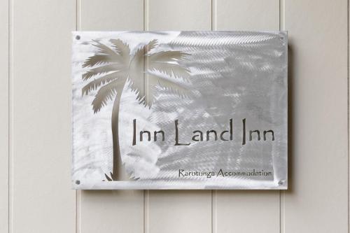 a book with a palm tree on a wall at Inn Land Inn in Vaimaanga