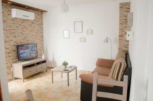 sala de estar con sofá y TV en Apartamentos RuiSol - AUTO CHECKIN - by Centrall alquileres turísticos, en Nerja