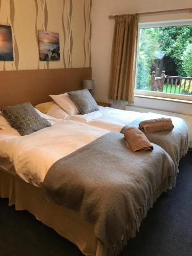 two large beds in a bedroom with a window at Merok Lodge in Great Eccleston