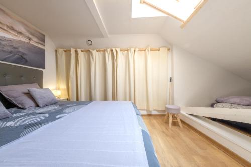 um quarto com uma cama grande e uma janela em Beau Duplex 54m2, classé 3 étoiles et Label "Gîte de France" 5min centre, 15min gare CLIMATISATION, Calme, 2 chambres, NETFLIX WIFI, TV 140cms, parking, boite à clés arrivée tardive - Gîtes La Tarine - em Pallud