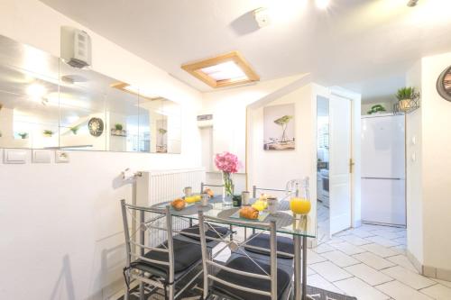 - une cuisine avec une table et des fruits dans l'établissement Beau duplex 54m2, CLIMATISATION, 3 étoiles, Gîte de France, 2 ch, calme, TV 140cm, parking, Netflix, wifi, 400m centre, boîte à clés, Gîtes La Tarine, à Albertville