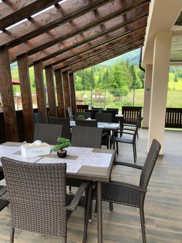 a patio with tables and chairs on a porch at Pensiunea Maria in Colibiţa