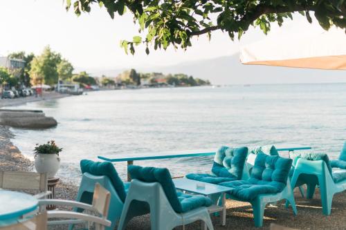 a group of chairs and tables next to the water at Plaz Hotel in Selianitika