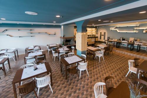 a restaurant with wooden tables and chairs and tablesktop at Plaz Hotel in Selianitika
