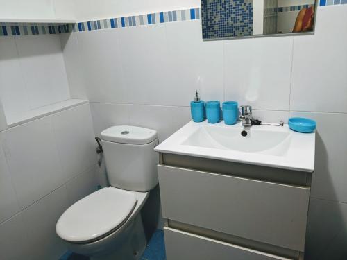 Un baño blanco con inodoro y lavabo. en Estudio Las Rotas, en Denia