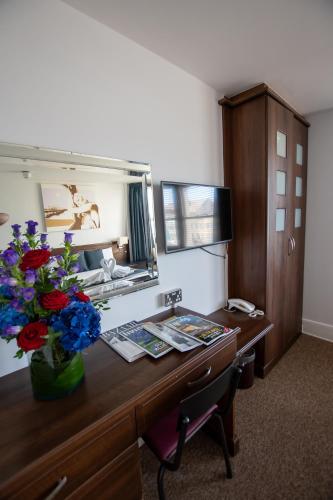 an office with a desk with a vase of flowers on it at New Steine Hotel - B&B in Brighton & Hove