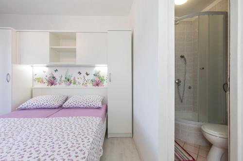 niewielka sypialnia z łóżkiem i łazienką w obiekcie Apartment & rooms Ivica w Krku