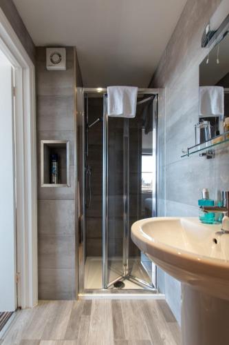 a bathroom with a shower and a sink at New Steine Hotel - B&B in Brighton & Hove