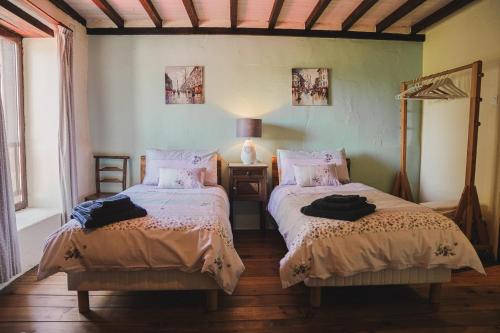 une chambre avec deux lits et une table avec une lampe dans l'établissement Michouat, à Vidou