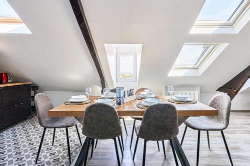une salle à manger avec une table et des chaises en bois dans l'établissement Appartement Lucarnes - 3 étoiles - Welkeys, à Honfleur