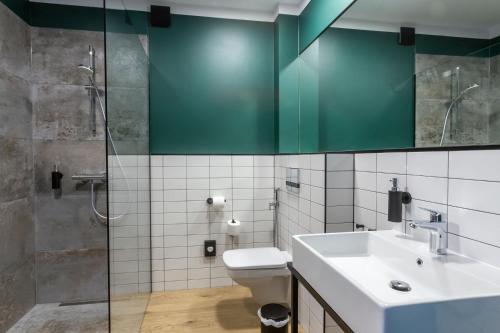 a bathroom with a toilet and a sink and a shower at OTTON-Charzykowy Bed&Restaurant in Chojnice