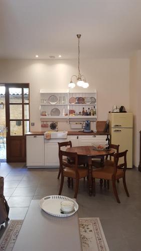 a kitchen with a wooden table and a kitchen with a refrigerator at Appartement Le Cardinal in Sarlat-la-Canéda