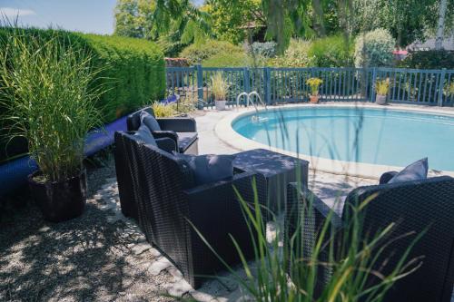 une piscine avec des chaises à côté d'une clôture dans l'établissement Michouat, à Vidou