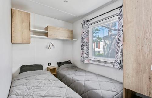 Llit o llits en una habitació de Particulier loue ce mobil-home 3 chambres, tout confort