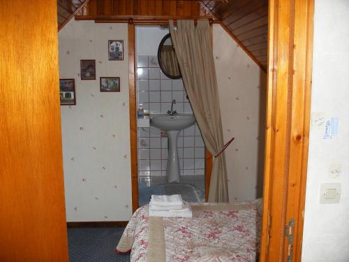 ein Bad mit einem Waschbecken und ein Bett in einem Zimmer in der Unterkunft Les chambres d'hotes du cosquer in Beuzec-Cap-Sizun