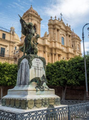 a statue in front of a building at Quattroquarti Stradivari Home in Noto