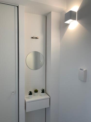 a bathroom with a sink and a mirror at Moov'Appart Hotel Clichy in Clichy