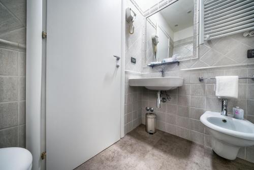 a bathroom with a sink and a toilet and a mirror at Hotel Varese in Rome