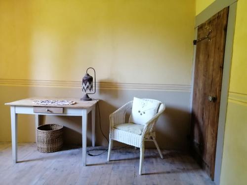 La Ferme du Crouzet في Rimeize: طاولة بيضاء وكرسي في غرفة