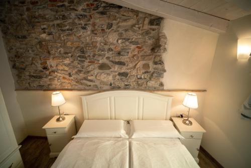 1 dormitorio con 1 cama blanca y 2 mesitas de noche en Garni Gianmartin, en Limone sul Garda