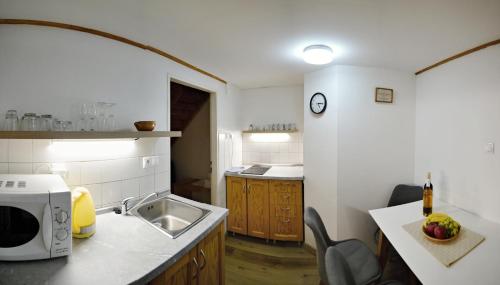 a kitchen with a sink and a microwave at Penzión Jozef a apartmány in Demanovska Dolina