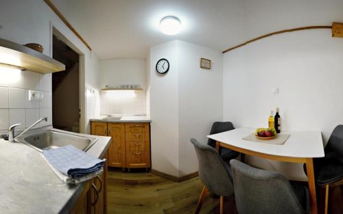 a kitchen with a sink and a table with chairs at Penzión Jozef a apartmány in Demanovska Dolina