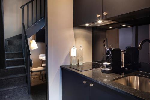 uma cozinha com um lavatório e uma escada num quarto em Rayz Eiffel em Paris