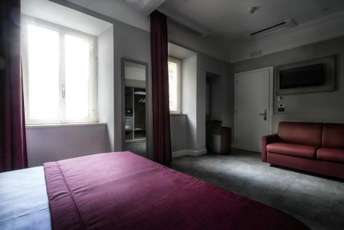 a bedroom with a bed and a red couch at Hotel Varese in Rome