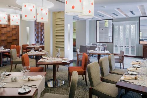 un restaurante con mesas, sillas y lámparas de araña en Crowne Plaza Sohar, an IHG Hotel en Sohar