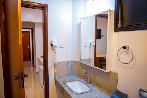 uma casa de banho com um lavatório e um espelho em Hz Hotel em Patos de Minas