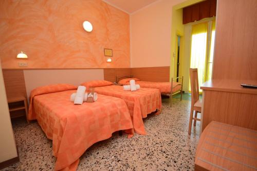a hotel room with two beds with orange sheets at Hotel Firenze in Bellaria-Igea Marina