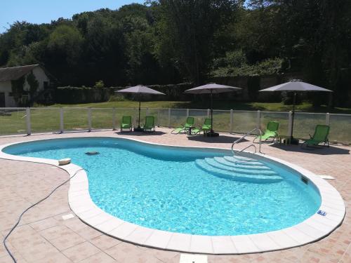 une grande piscine avec des chaises et des parasols dans l'établissement Chateau Gruchet Le Valasse, à Gruchet-le-Valasse