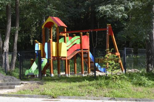 - une aire de jeux dans un parc avec un toboggan coloré dans l'établissement SŁOŃCE WODA LAS Apartament No 11A, à Kielce