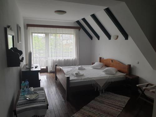 a bedroom with a bed and a large window at Pensiunea Passiflora in Mănăstirea Humorului