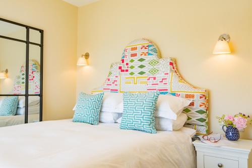 a bedroom with a white bed with a large headboard at Boatman's Reading Rooms in Deal