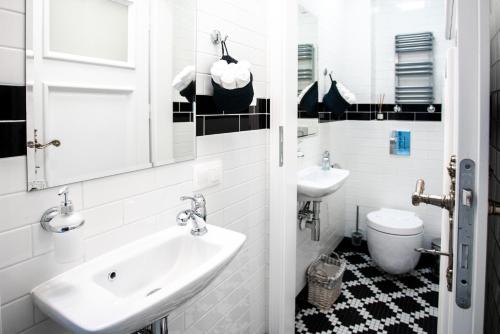 a white bathroom with a sink and a toilet at Willa Krakowska in Raszyn