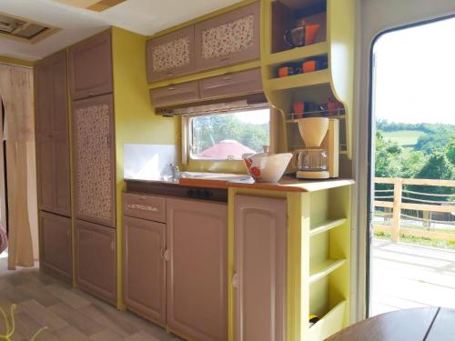 a kitchen with a sink and a counter with a window at cararetro , caravane chauffée et climatisée in Saint-Sylvain-Bellegarde