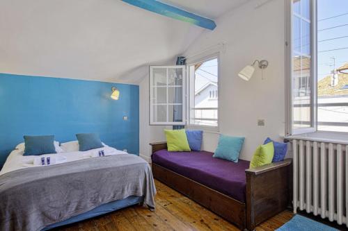 1 Schlafzimmer mit 2 Betten und einem lila Sofa in der Unterkunft Charming Basque villa with garden - Bayonne - Welkeys in Bayonne