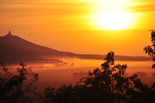 a misty sunrise with the sun in the background at Hotel-Restaurant Weinberg in Artern
