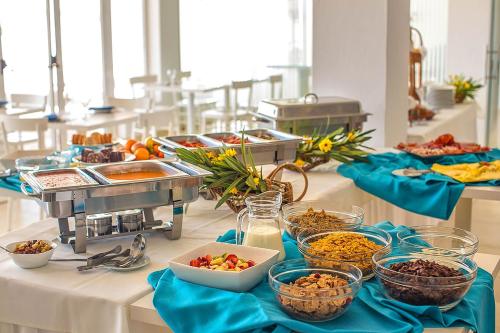 Una línea de buffet con tazones de comida en una mesa en Aldeamento Turistico da Prainha, en Alvor