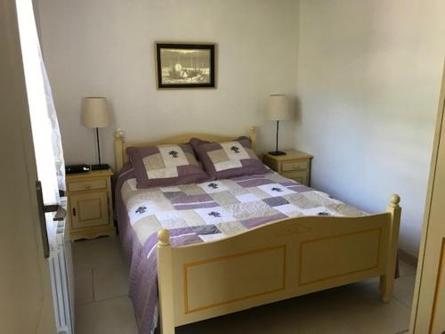 ein Schlafzimmer mit einem Bett und zwei Nachttischen mit zwei Lampen in der Unterkunft Villa Henri IV in La Couarde-sur-Mer