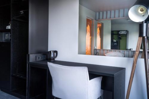 uma secretária com uma cadeira branca e um espelho em Live Lofoten Hotel em Stamsund