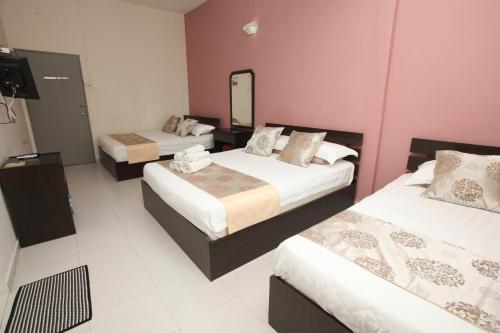 a hotel room with two beds and a mirror at WARNI 45 Whole Or Room in Muar