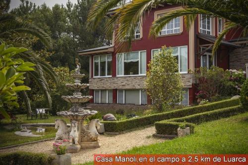 una casa con una fontana di fronte a una casa di Casa Manoli Luarca ad Almuña