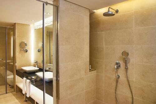 a bathroom with a shower and a sink at Mercure Dubai Barsha Heights Hotel Suites And Apartments in Dubai