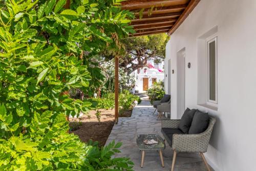 an outdoor patio with a couch and chairs and trees at Secret Garden Apartments in Mýkonos City