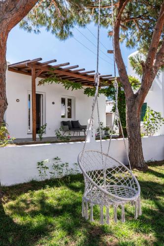 a swinging chair in the yard of a house at Secret Garden Apartments in Mýkonos City