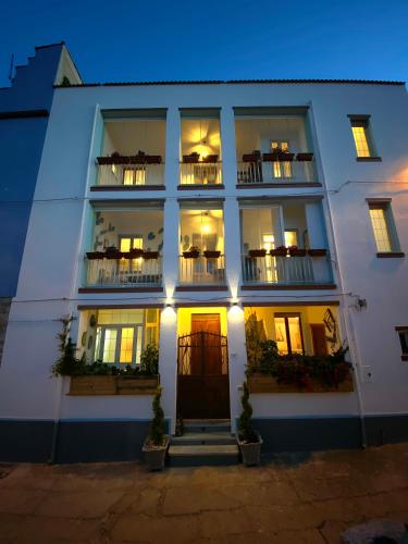 a white building with windows and balconies at night at Canduleri in Orgosolo